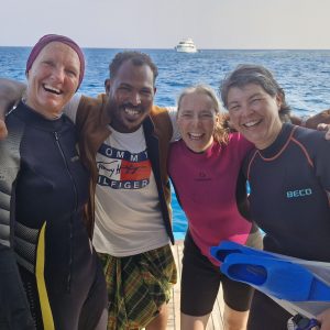 drei Frauen und ein Mann lachen gemeinsam